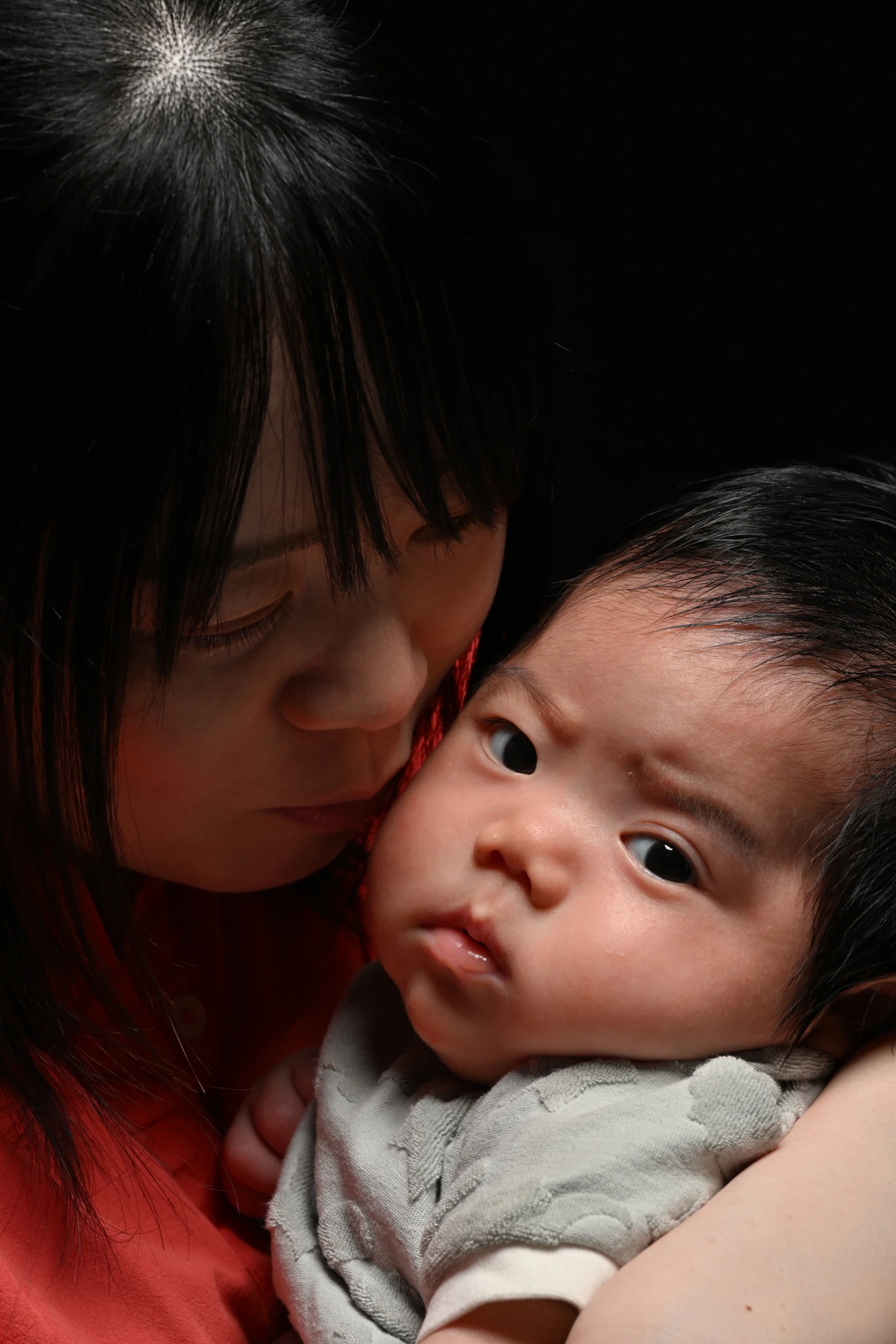 赤ちゃんに頬を寄せる母親のMOTHER & BABY写真