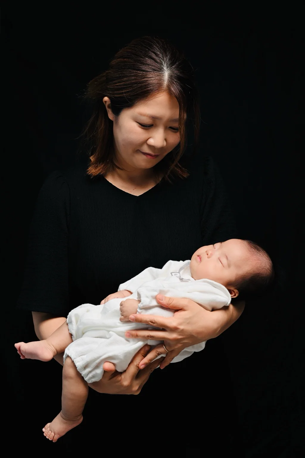 光と影の中で赤ちゃんを抱く母親のポートレート